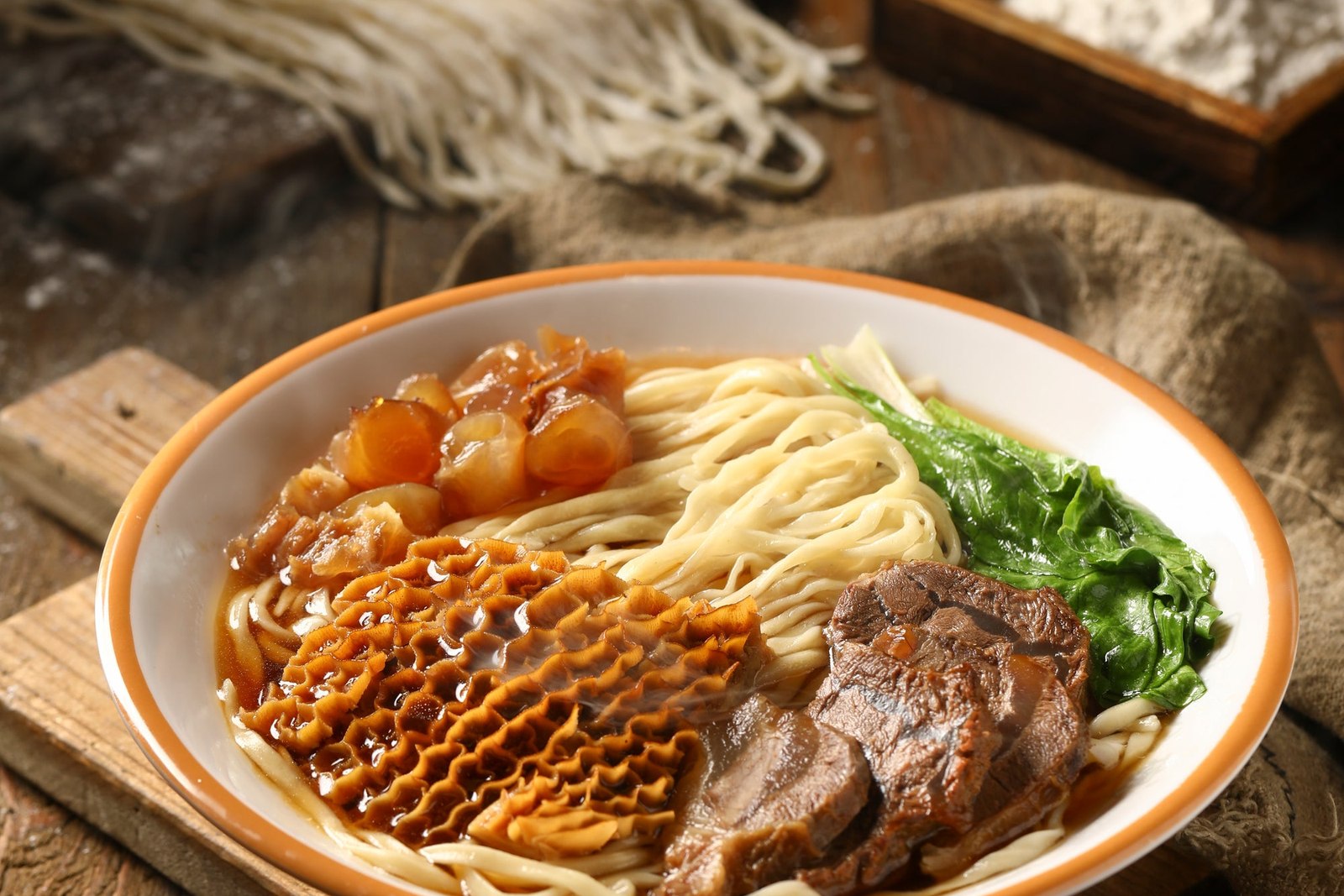 Steaming Bowl Of Noodle Soup On A Wooden Surface