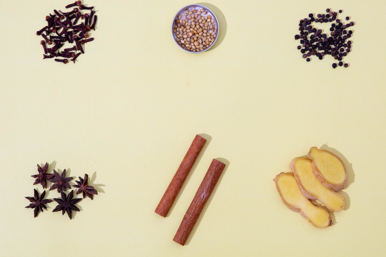 Six Different Spices Against A Yellow Background